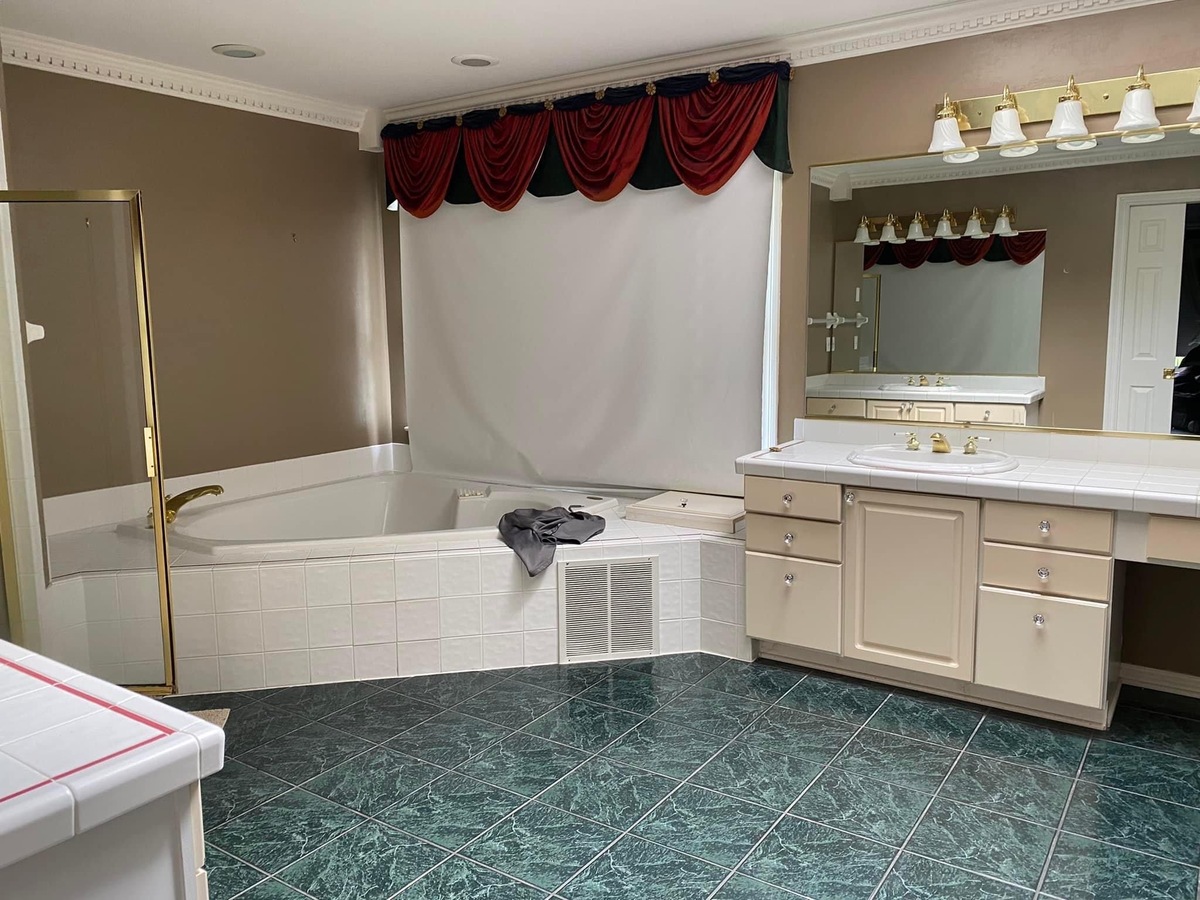 bathroom with tub, vanity, and blue floor tile